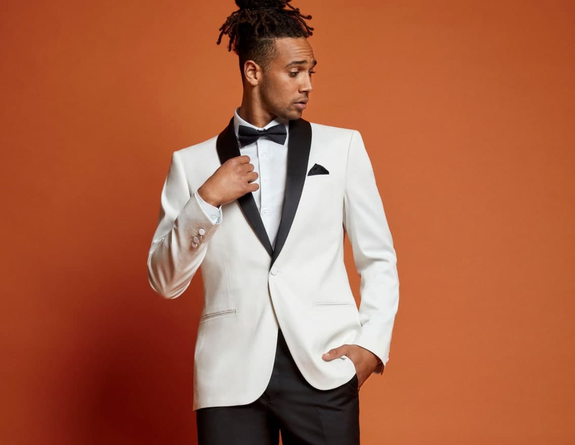 Man in white tuxedo on an orange background