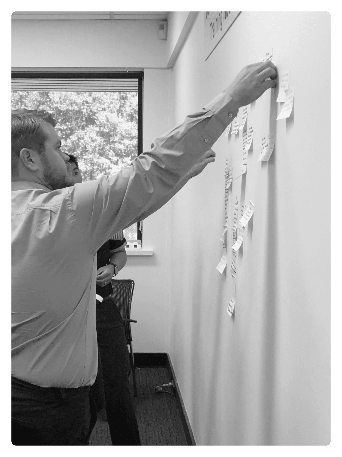 Man placing sticky notes on a wall