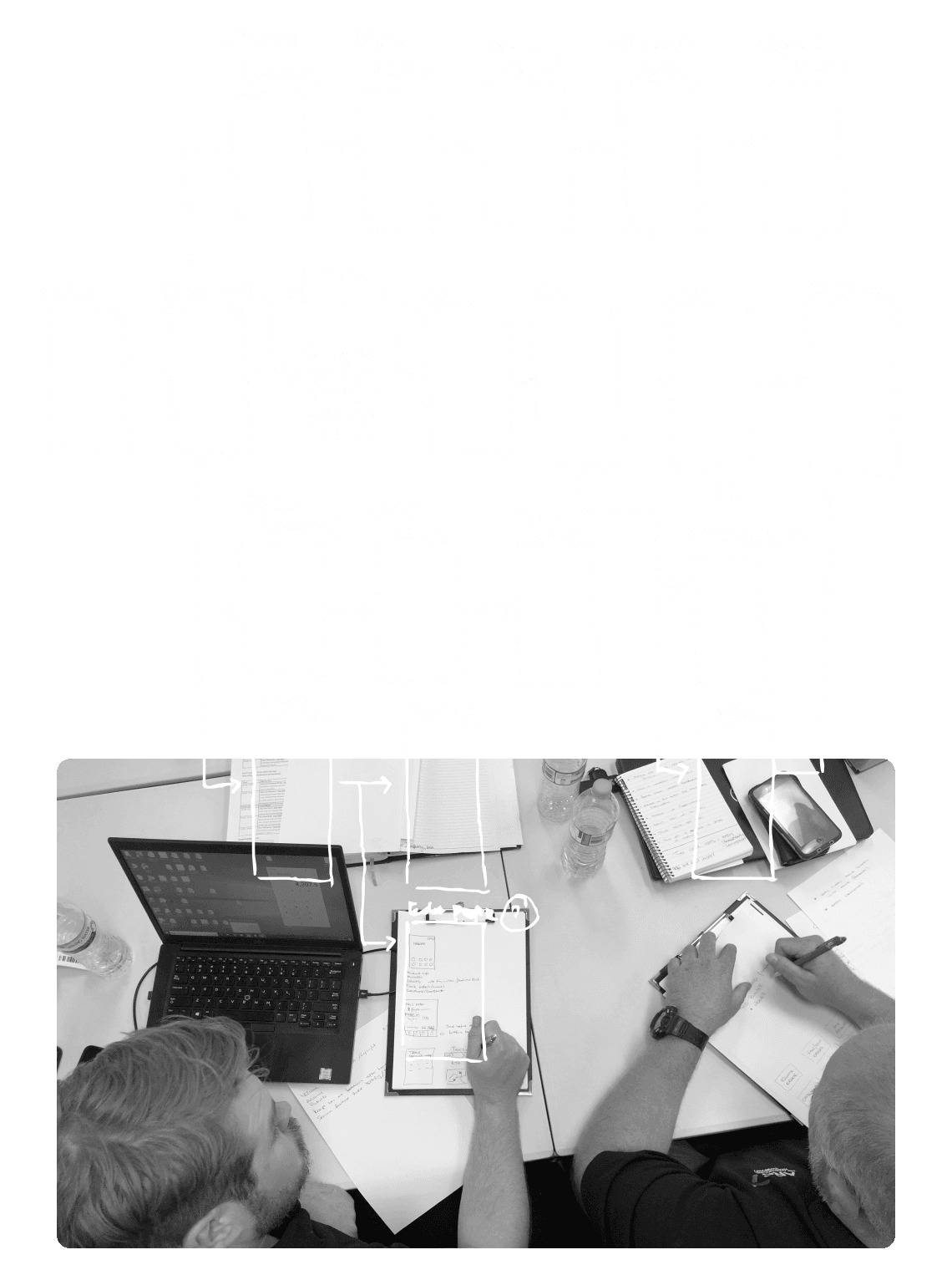 Sketched user flows and an image of two people writing on paper