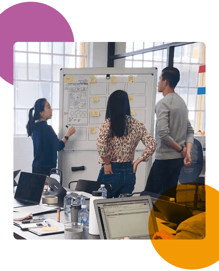 Group of people brainstorming at a whiteboard