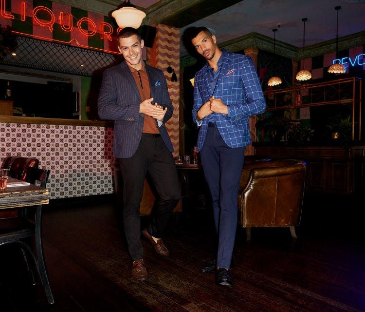 Two men standing in a bar at night